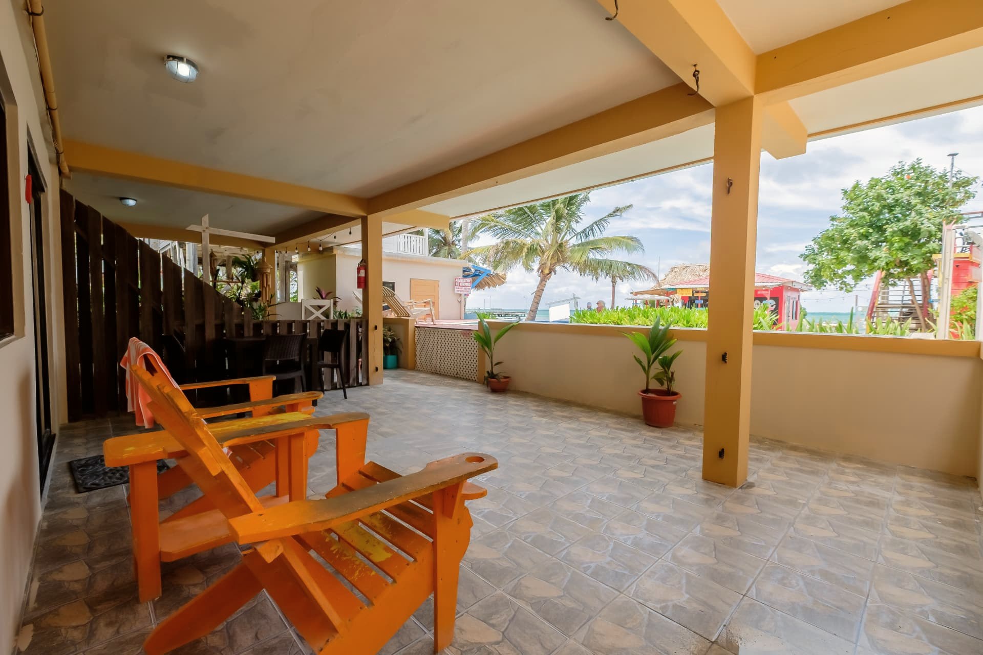 Überdachte Terrasse mit orangefarbenen Liegestühlen mit Blick aufs Meer