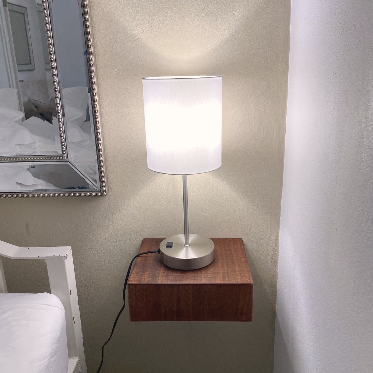 Nachttisch aus massivem Holz mit Lampe neben dem Bett